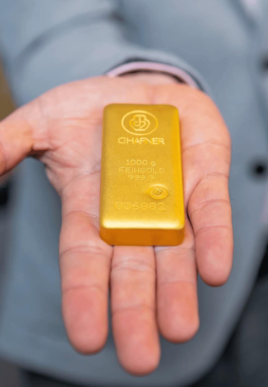 Ein Goldbarren auf einer Hand.
